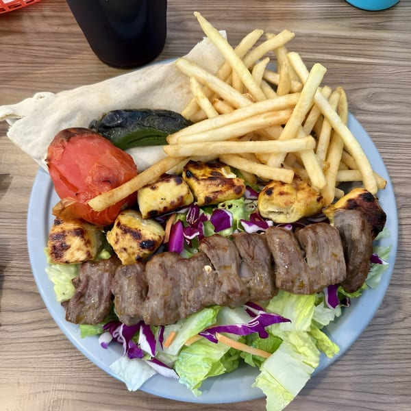 LA Tacos & Kabobs' plate with beef and chicken kabobs, fries, grilled vegetables, and salad.