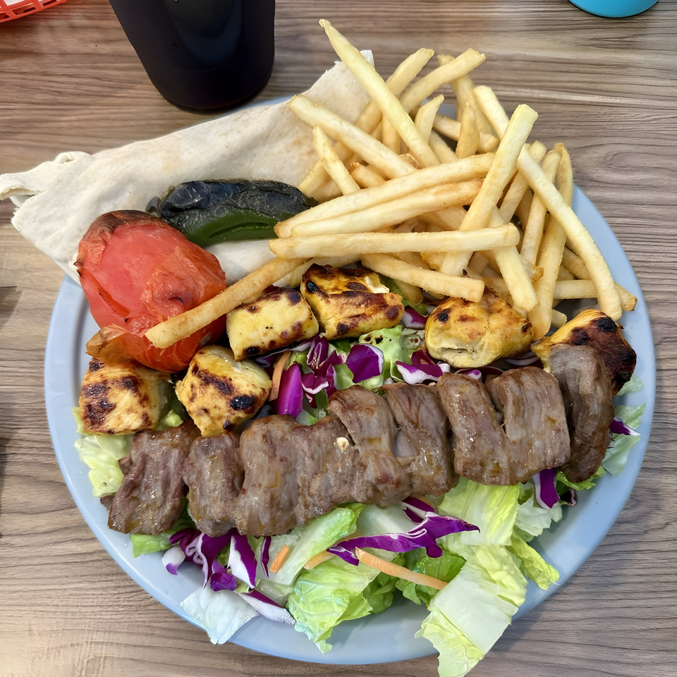 LA Tacos & Kabobs' plate with beef and chicken kabobs, fries, grilled vegetables, and salad.